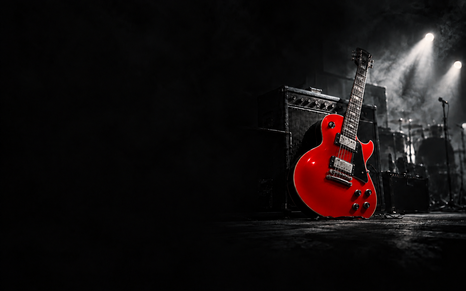 A guitar with a clean glossy red face, black pickguard, neutral metallic hardware and cream binding beside an amplifier on a dark stage.